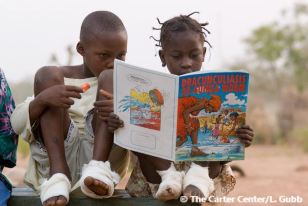 Children reading book on Guinea Worm.