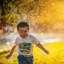 happy child playing in a sprinkler 