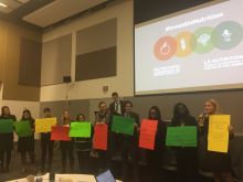 Conference attendees hold up poster boards with their own commitments.