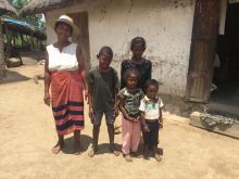 Lenenia outside her family home with her four grandchildren