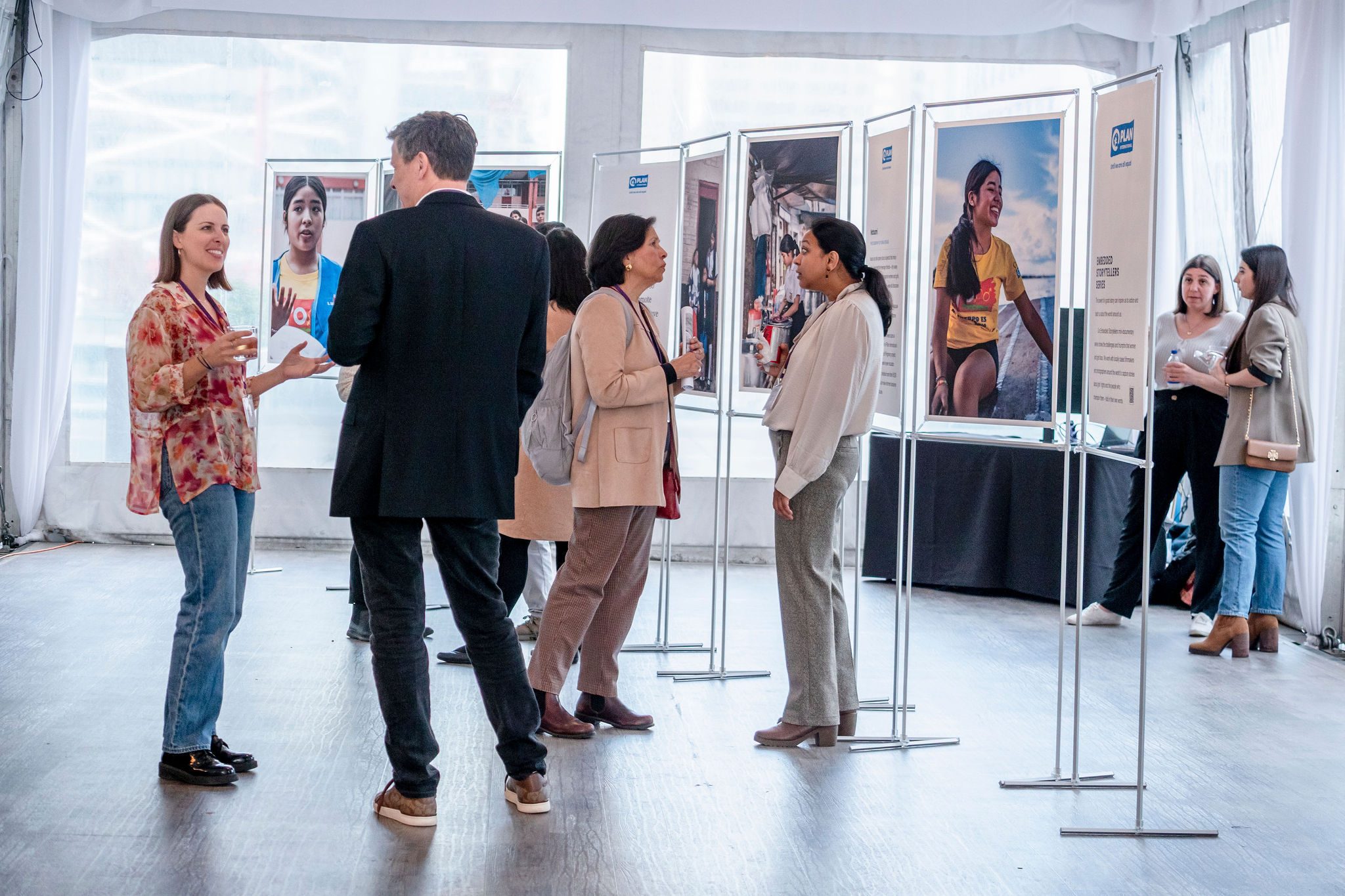 People networking and looking at a photo gallery display.